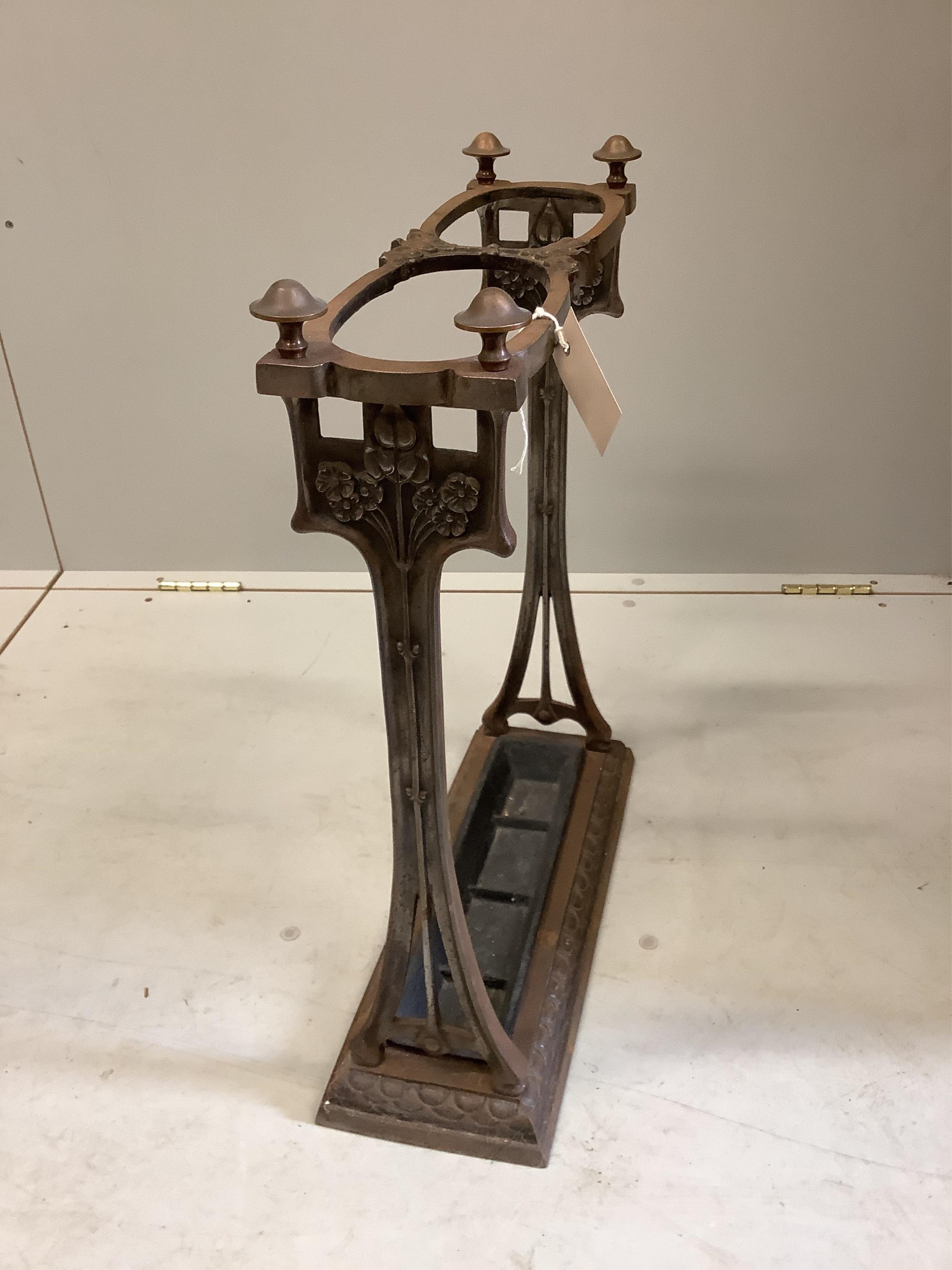 An Art Nouveau two division cast iron stickstand, width 44cm, depth 13cm, height 60cm. Condition - fair